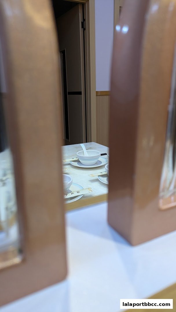 A table setting with bowls and chopsticks at a restaurant, viewed through decorative frames.