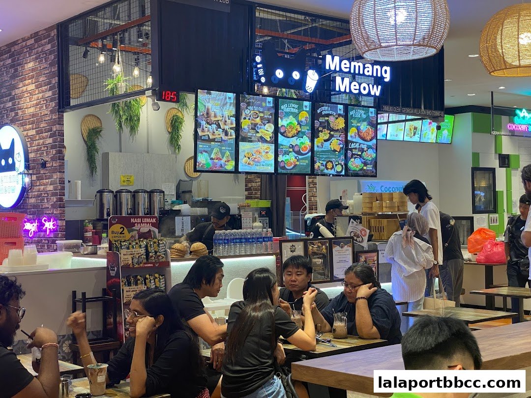 Customers dining at Memang Meow, a food stall with digital menus and a lively atmosphere.