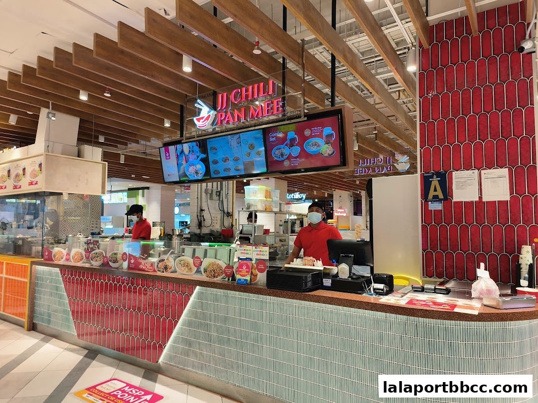 JJ Chili Pan Mee shop counter with staff and digital menu displays.