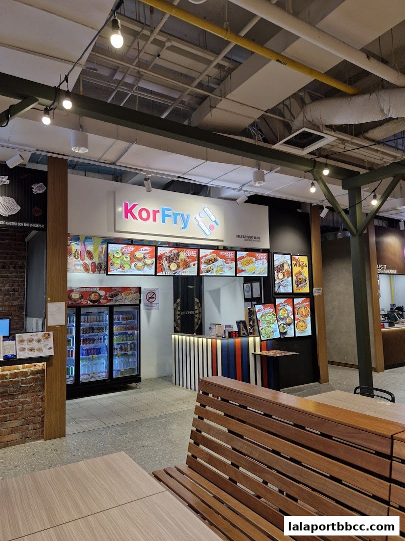 The KorFry shop front with illuminated menu boards and a display fridge.