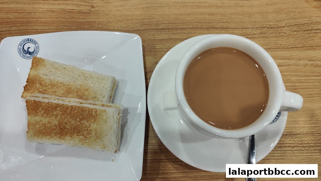 A close-up of toast and a cup of milk tea on a wooden table.