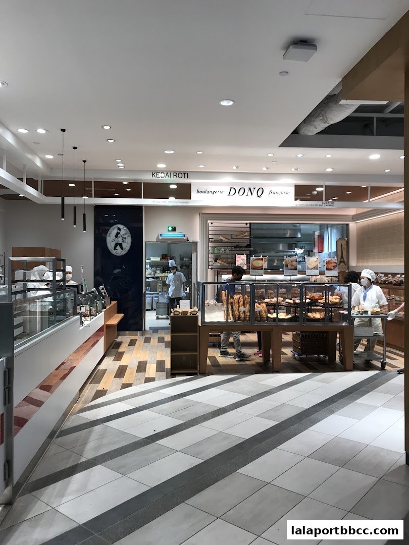 Interior view of a bakery with display cases filled with bread and pastries.