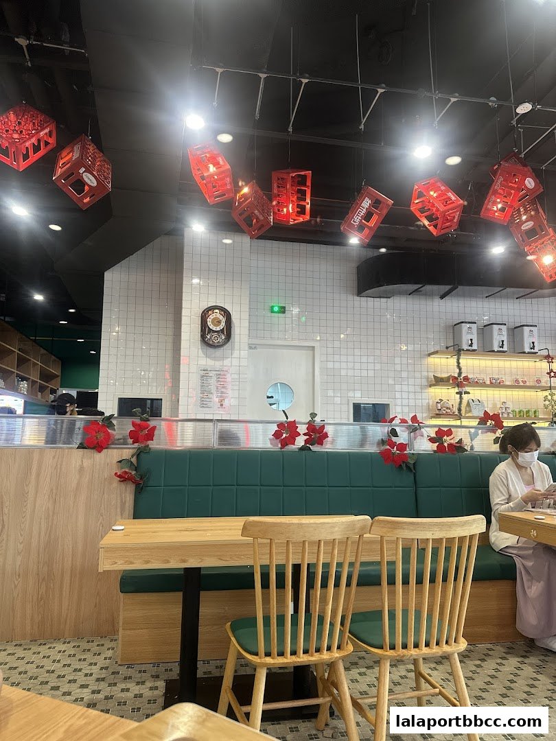 Interior of a restaurant with red decorative lanterns hanging from the ceiling and green booth seating.