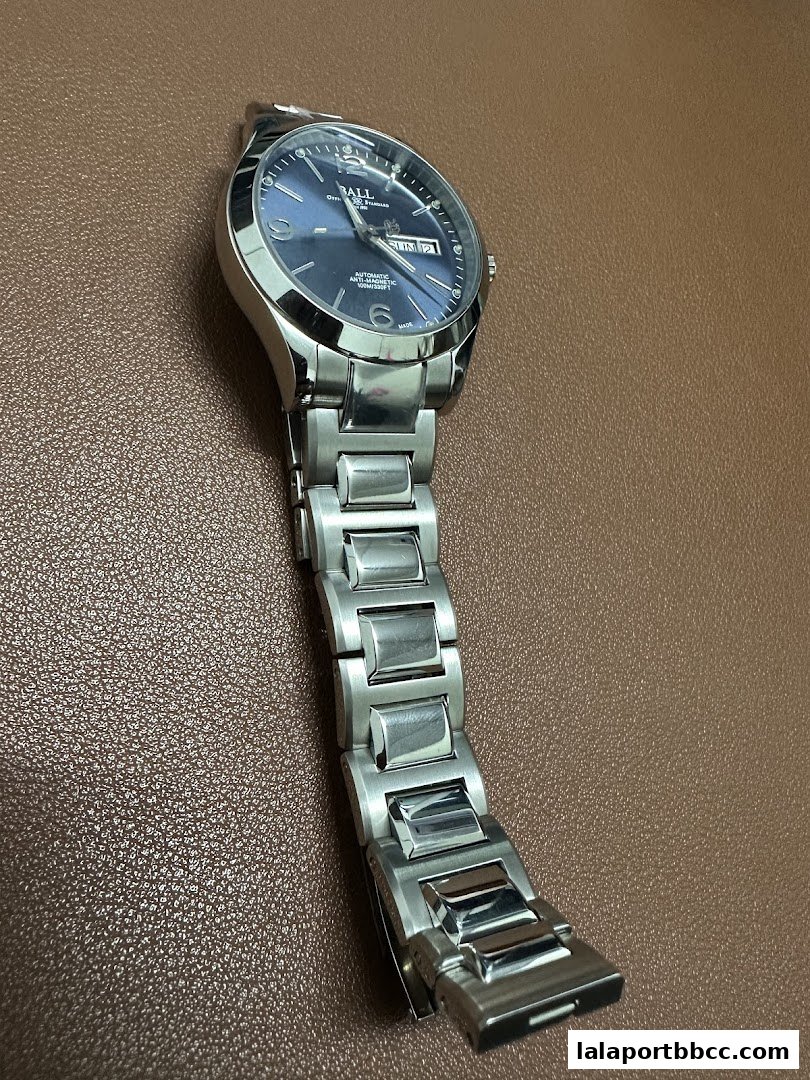 A close-up shot of a stainless steel automatic watch with a blue dial.