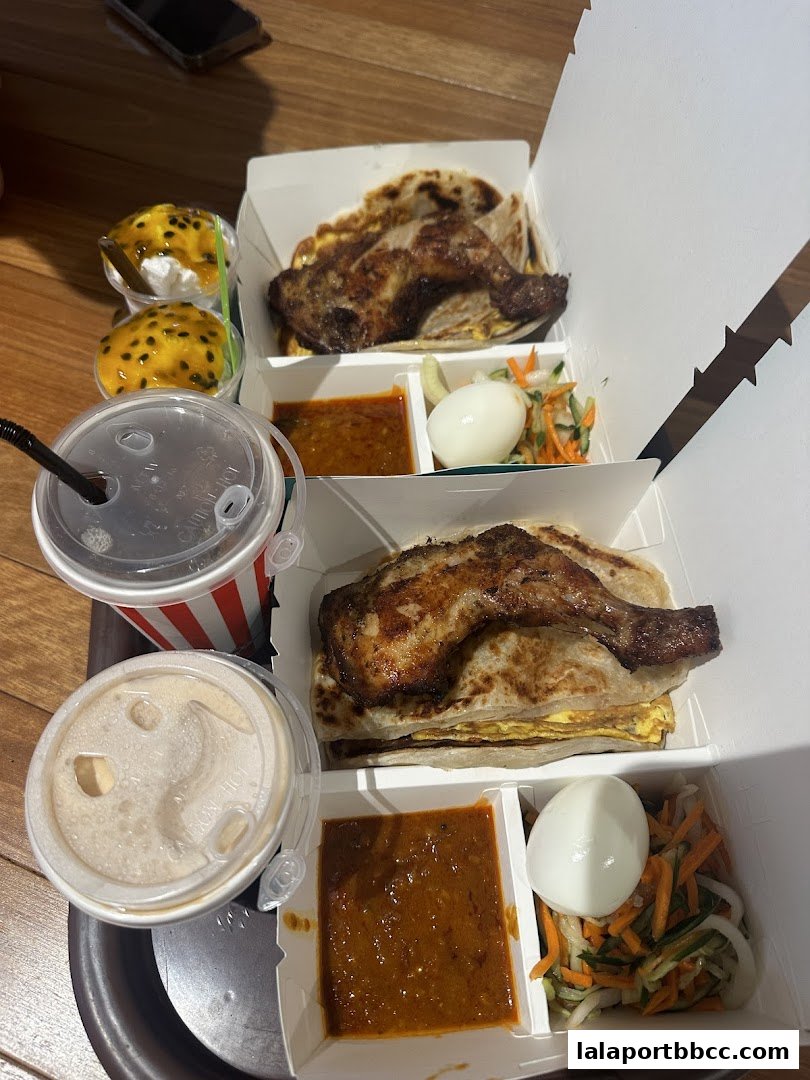 Two servings of roti canai with chicken, side dishes, and drinks, plus two desserts.