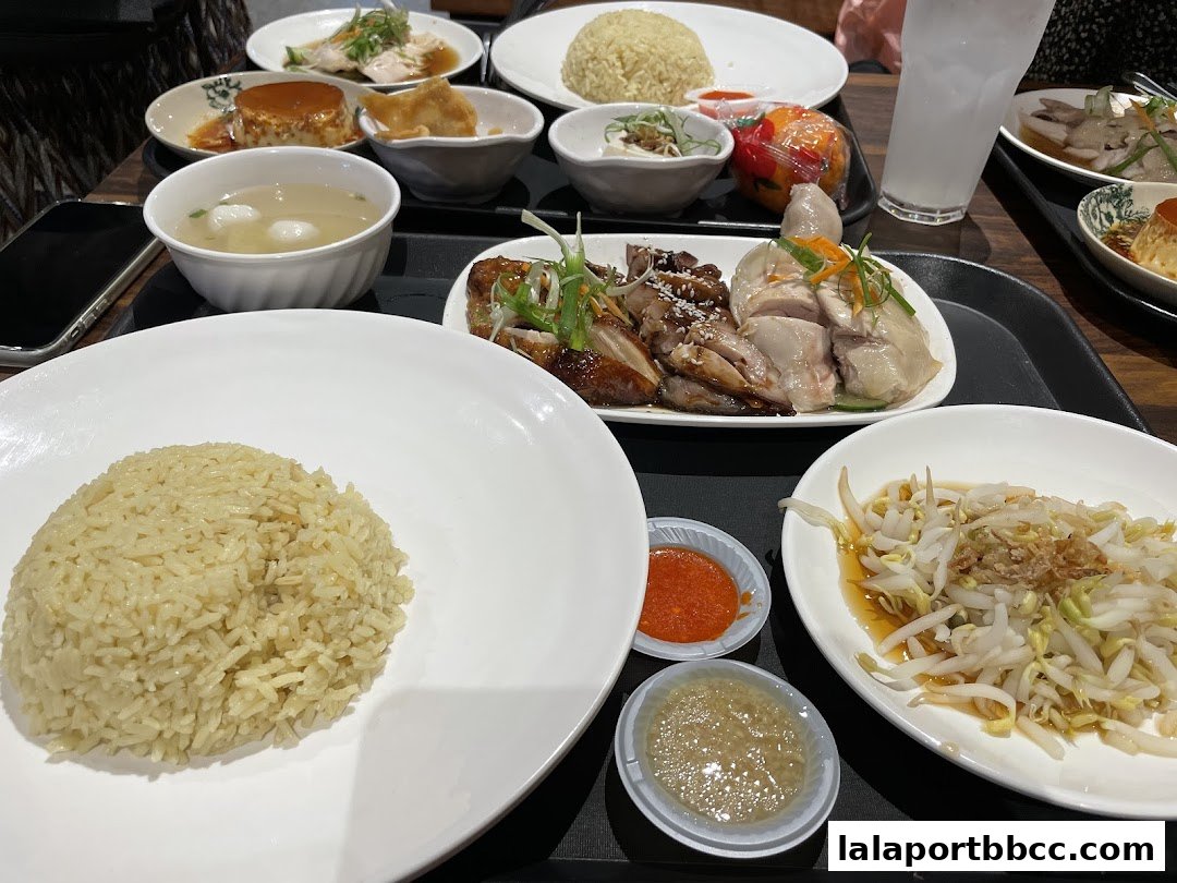 A table laden with various dishes, including chicken rice, soup, and side dishes.