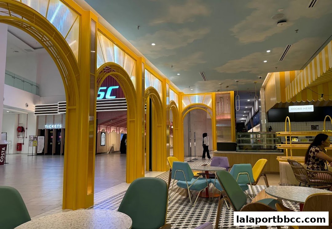 Interior view of a brightly decorated cafe with yellow arches and colorful seating.