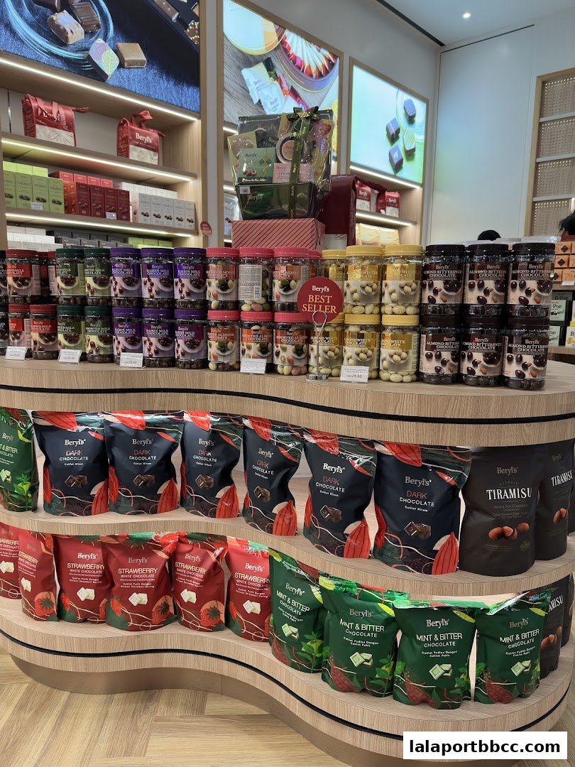 A display of various Beryls chocolates, including pouches and jars, on tiered shelves.