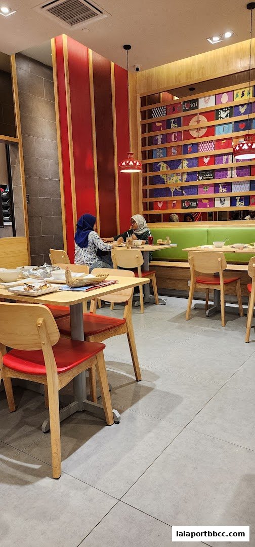 Interior view of The Chicken Rice Shop with diners seated at tables.