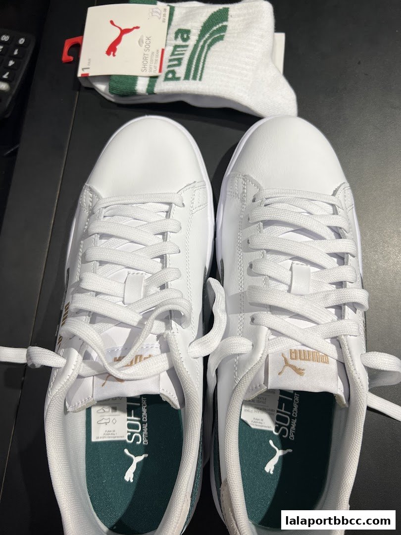 A pair of white Puma sneakers with matching socks, showcasing comfort and style.