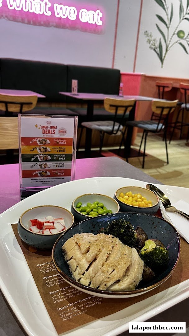 A meal with chicken, broccoli, corn, edamame, and imitation crab sticks is presented on a tray.