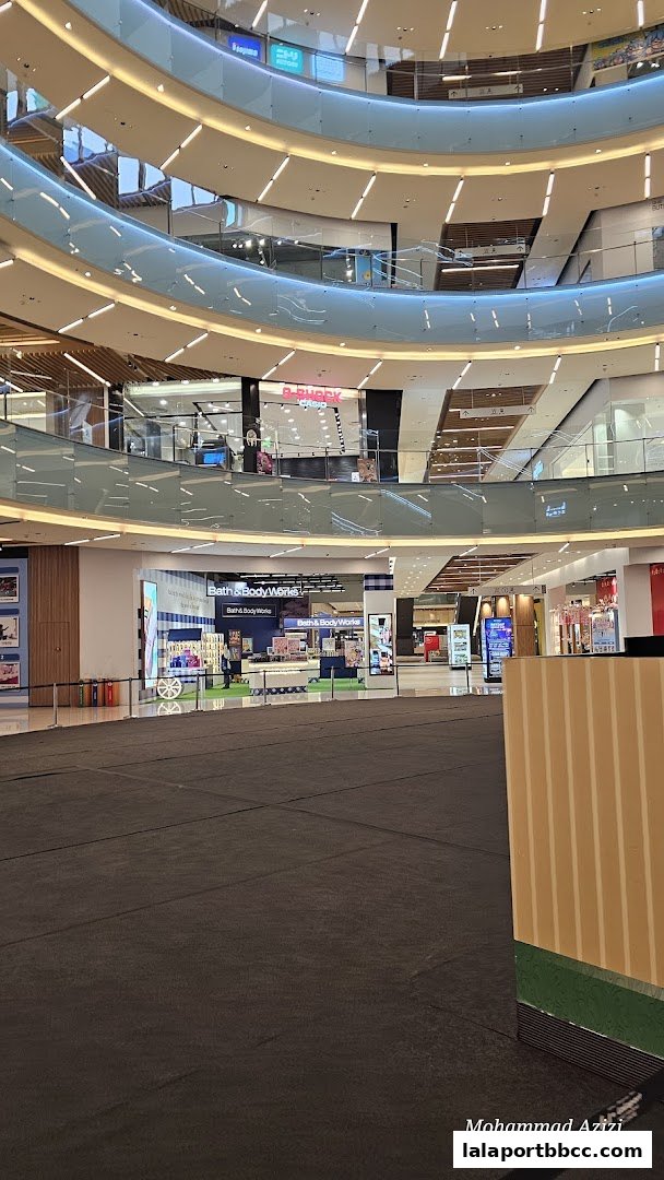 Interior view of a modern shopping mall with multiple levels and shops, including Bath & Body Works.