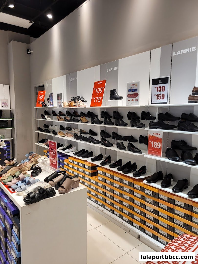 A well-lit shoe store interior with shelves displaying various women's footwear and price tags.