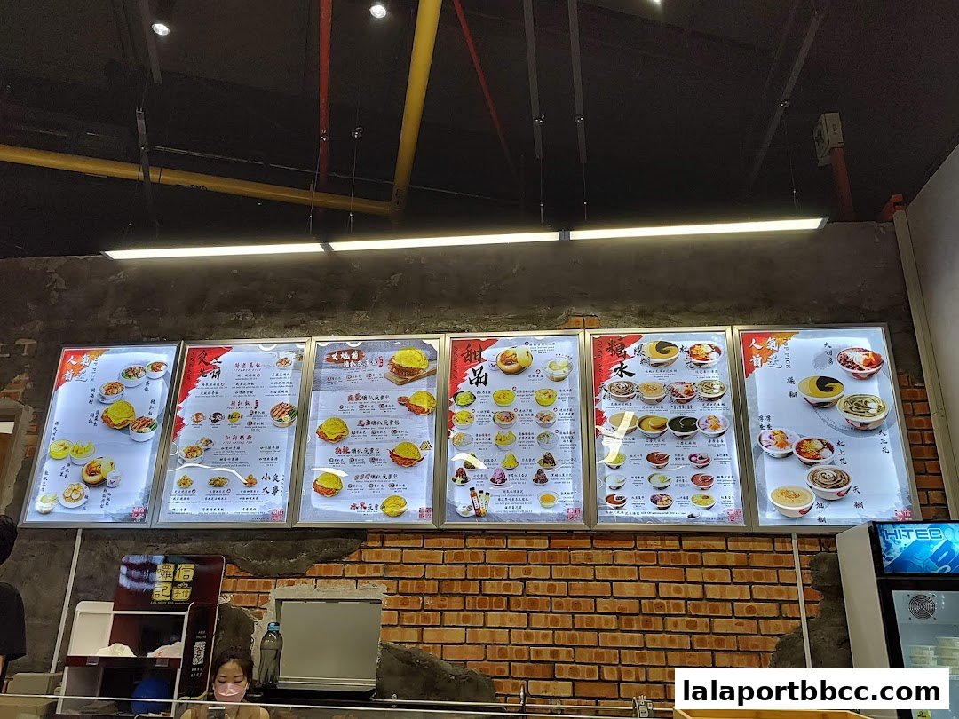 A brightly lit menu board displaying various dessert items with images and text.
