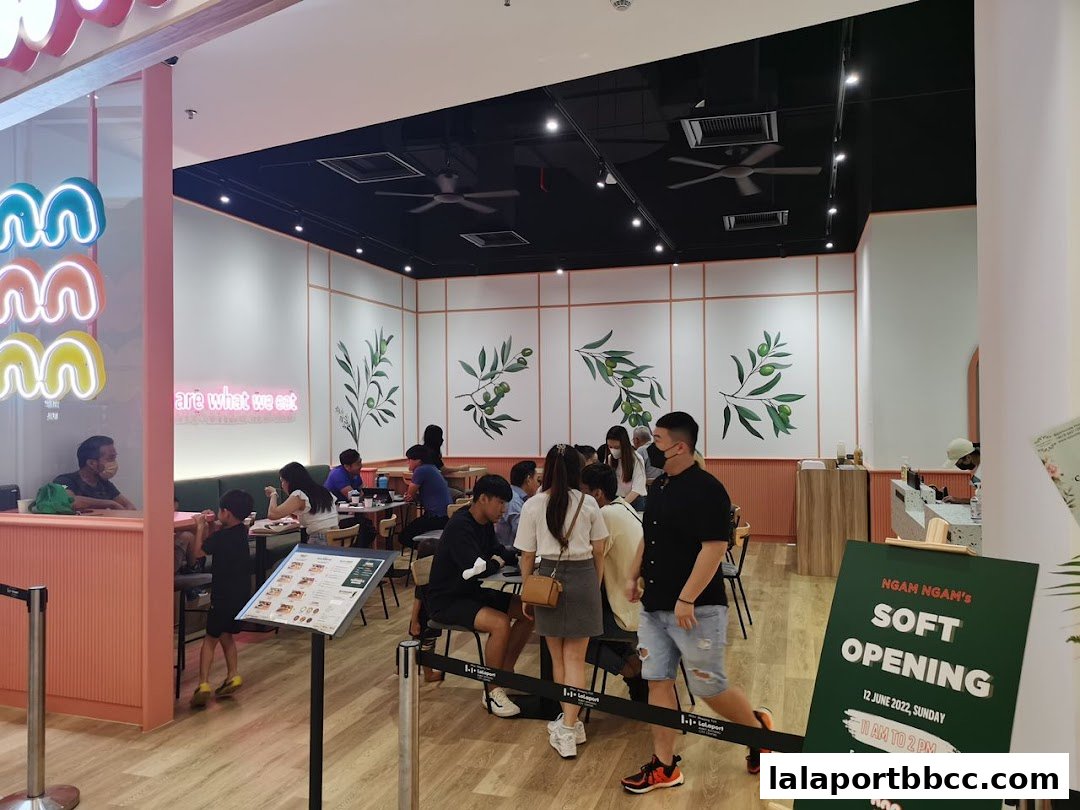 Interior of a restaurant with customers seated and a soft opening sign.