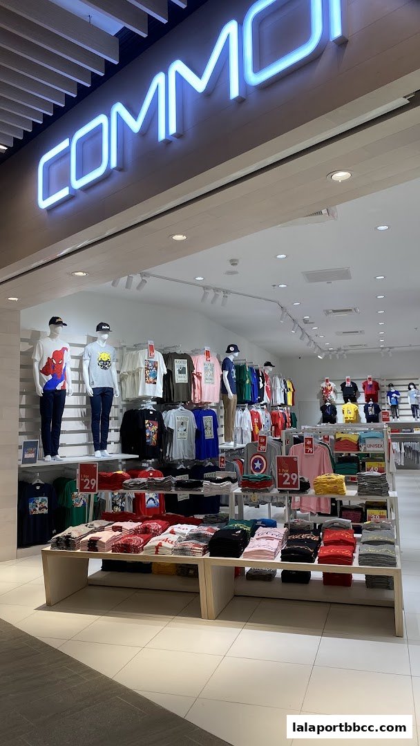 A brightly lit clothing store with mannequins displaying graphic t-shirts and racks of folded apparel.