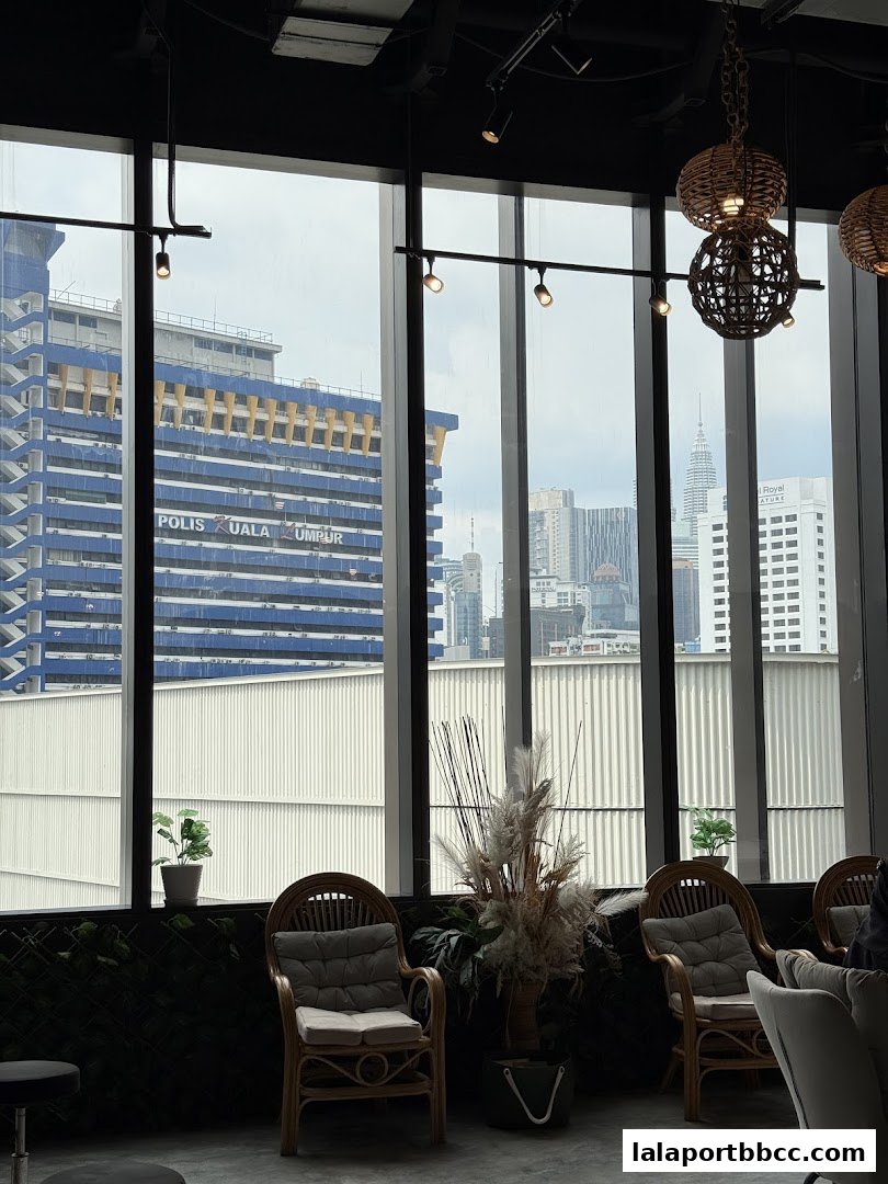 Interior view of a salon with chairs and a city skyline visible through the windows.