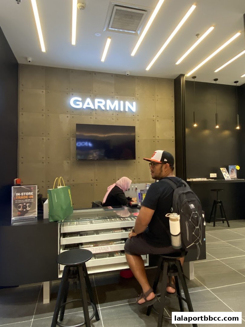 Interior of a Garmin store with a customer at the counter and products displayed.
