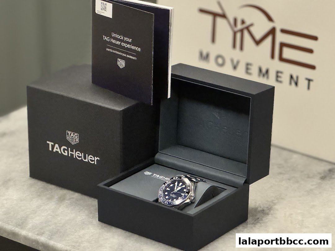 A TAG Heuer watch is displayed in its box with accompanying warranty information.