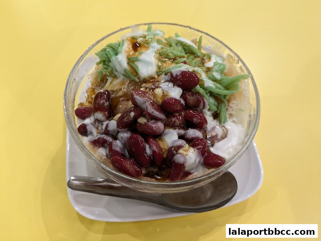 A refreshing bowl of Cendol with red beans, shaved ice, coconut milk, and gula melaka.