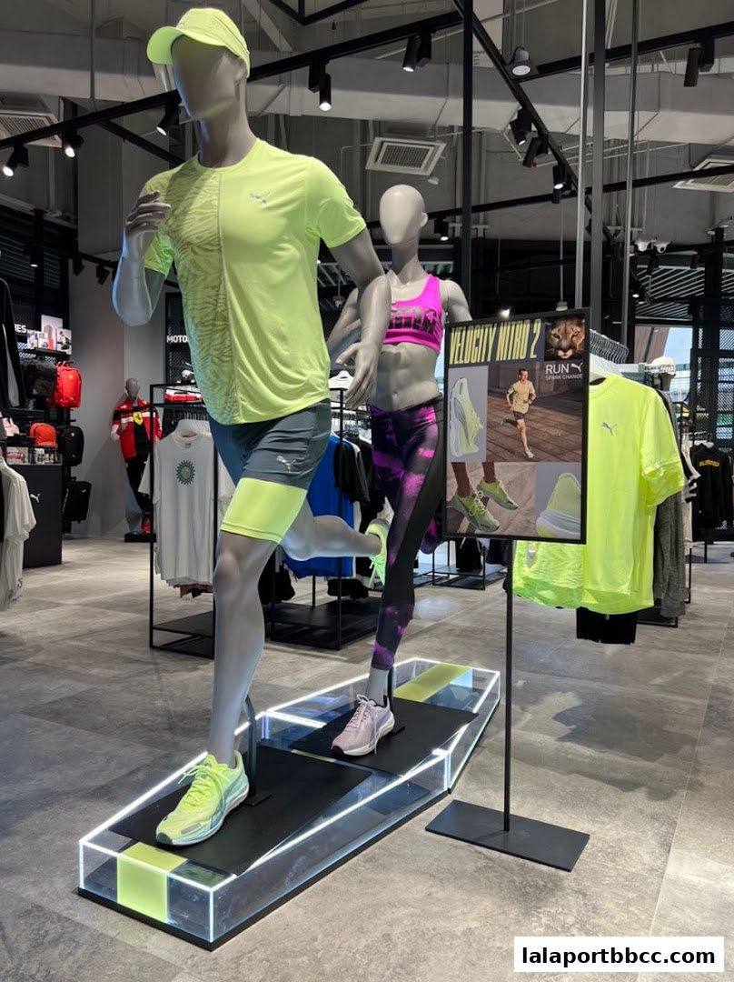 Mannequins dressed in PUMA running gear displayed in a brightly lit store.