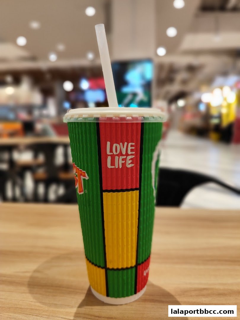 A close-up of a Boost Juice cup with a straw, featuring colorful branding.
