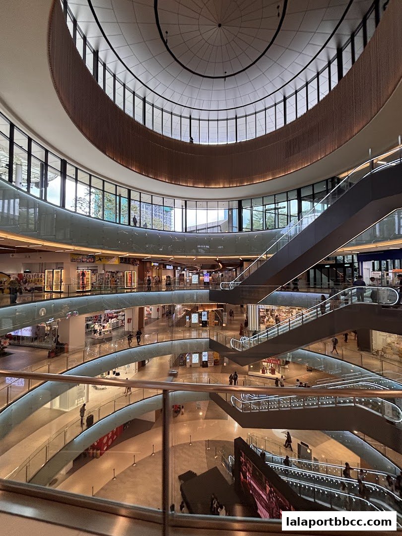 Interior view of a modern shopping mall with multiple levels and escalators.