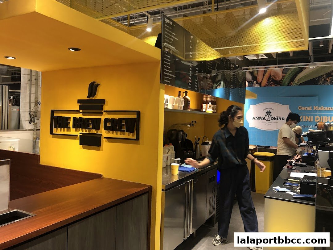 A bright yellow coffee shop interior with staff preparing drinks behind the counter.