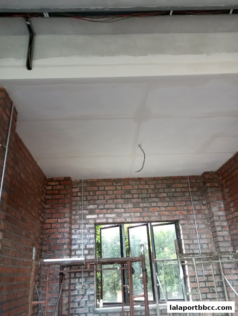 Interior view of a room under construction with exposed brick walls and electrical wiring.