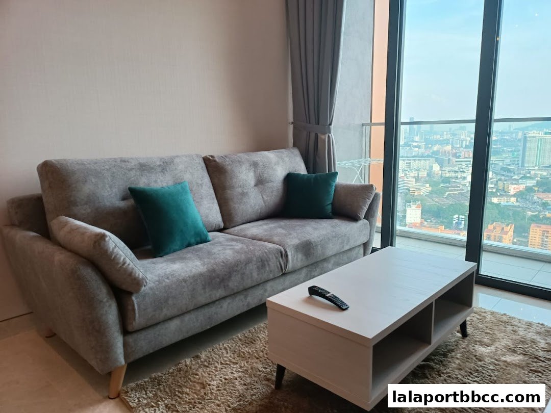 A modern living room with a grey sofa, teal cushions, and a coffee table with a remote.