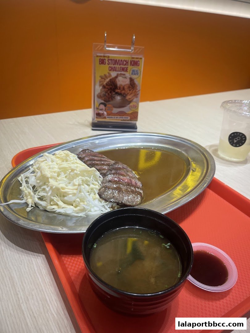 A delicious meal of sliced beef curry with shredded cabbage and miso soup.