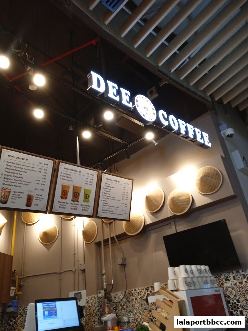 The Dee Coffee shop sign and menu boards are displayed above the counter.