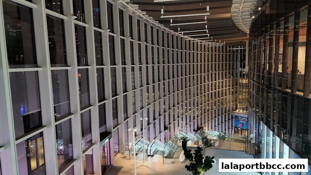 Modern interior of a shopping mall with large windows and escalators.