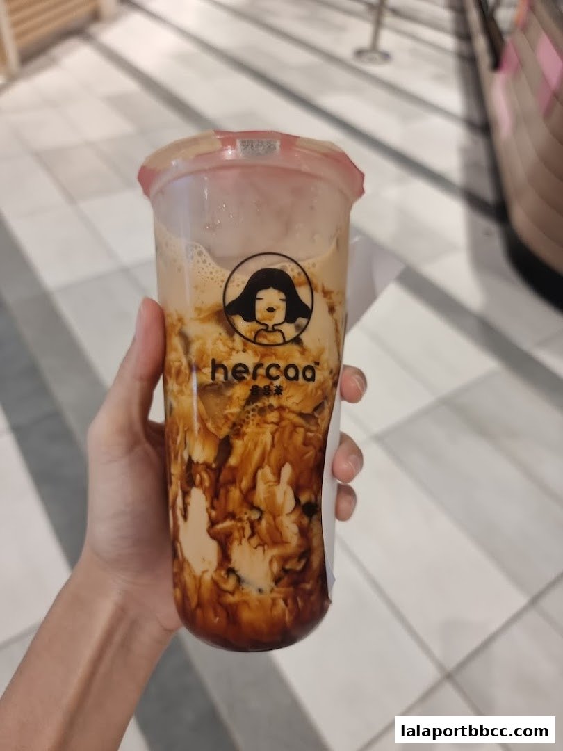 A hand holds a refreshing brown sugar bubble tea from Hercaa.