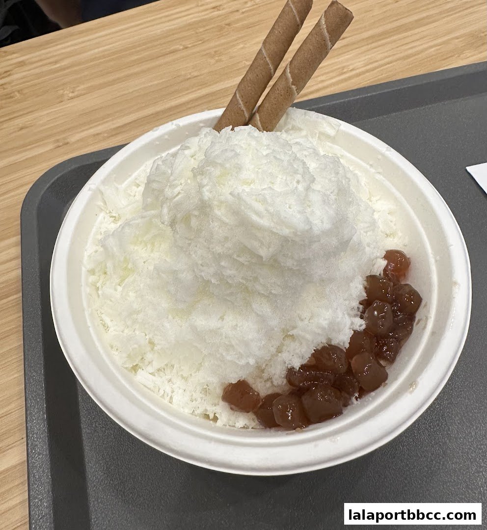 A refreshing bowl of shaved ice topped with wafer sticks and red bean paste.