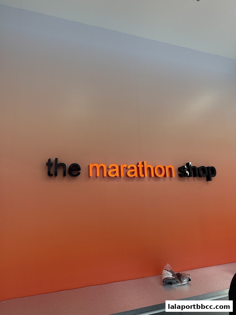 The Marathon Shop logo displayed on an orange gradient wall.
