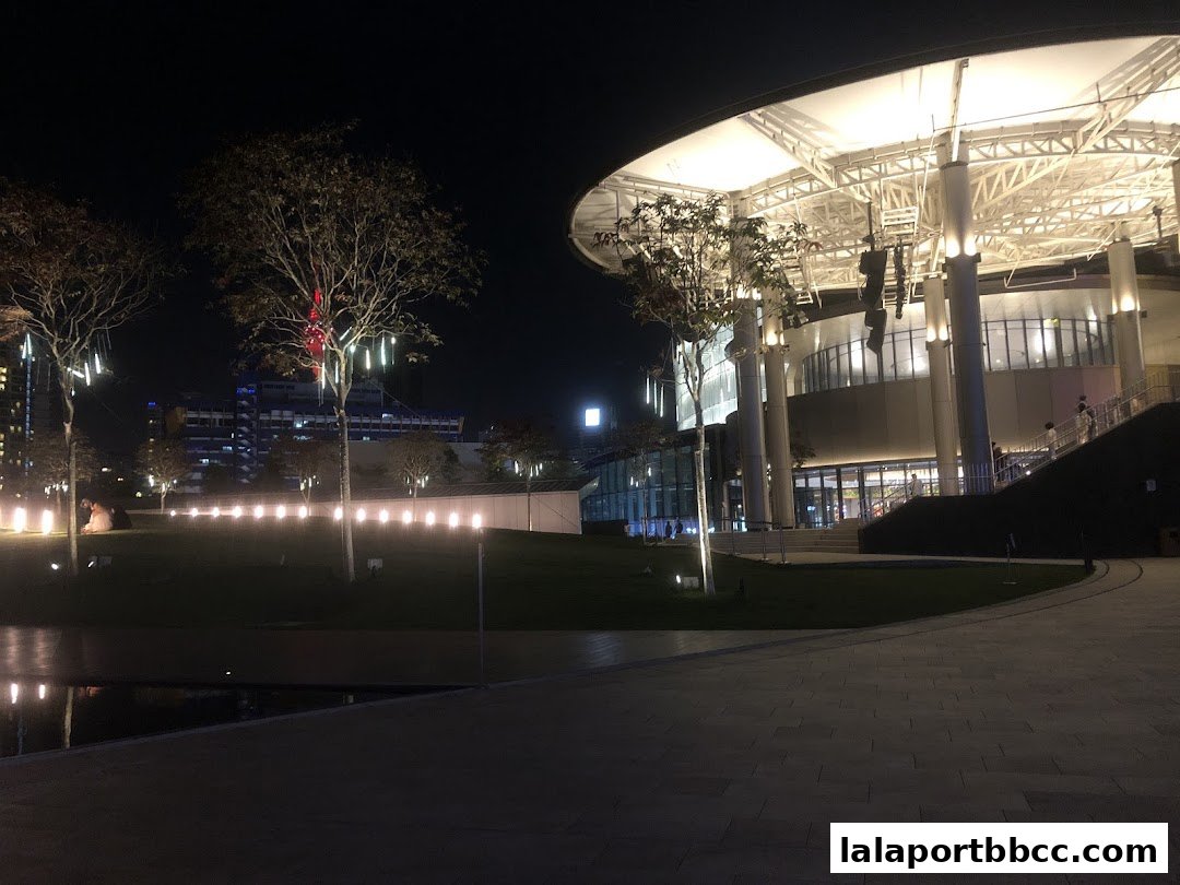 A modern building with a large, illuminated canopy at night.