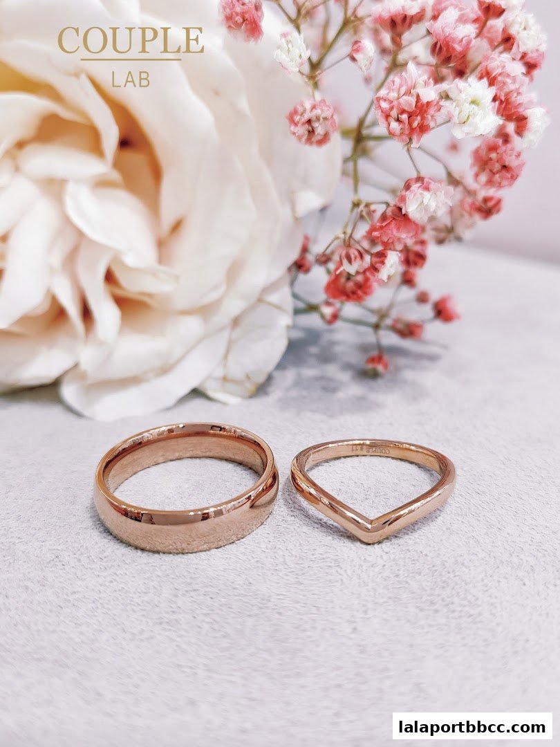Rose gold wedding bands displayed with delicate flowers.