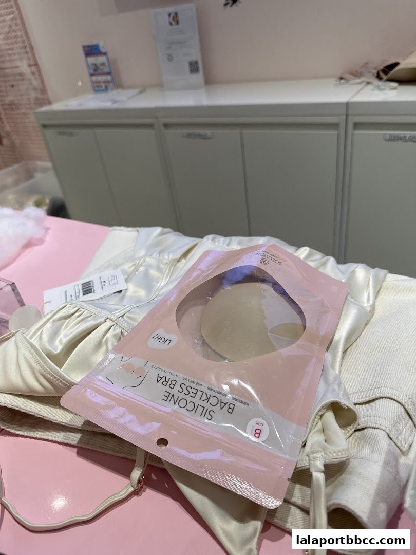 A package of silicone backless bra inserts rests on a satin camisole.