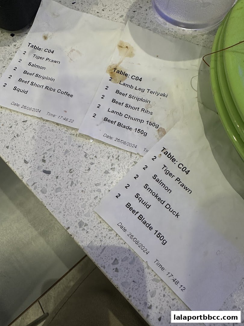 Close-up of order slips with food items and quantities on a counter.