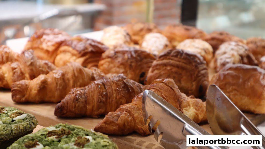 A close-up shot of freshly baked croissants and green pastries with white toppings.