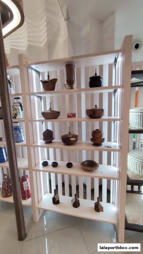 Shelves display various wooden bowls, vases, and decorative items, with woven baskets visible on the right.