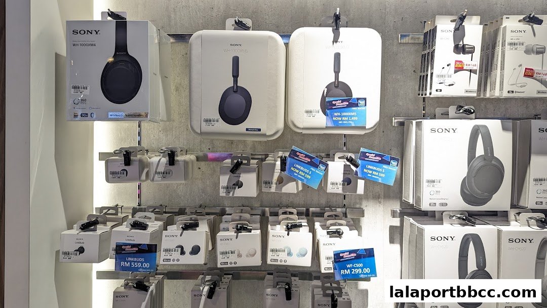 A wall display showcasing various Sony headphones and earbuds with product boxes and pricing.