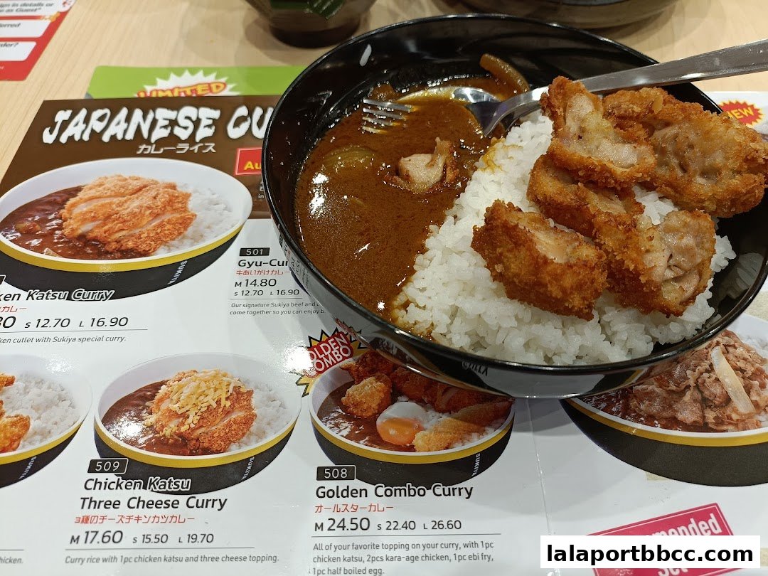 A close-up of Japanese curry dishes with rice and fried toppings from Sukiya.