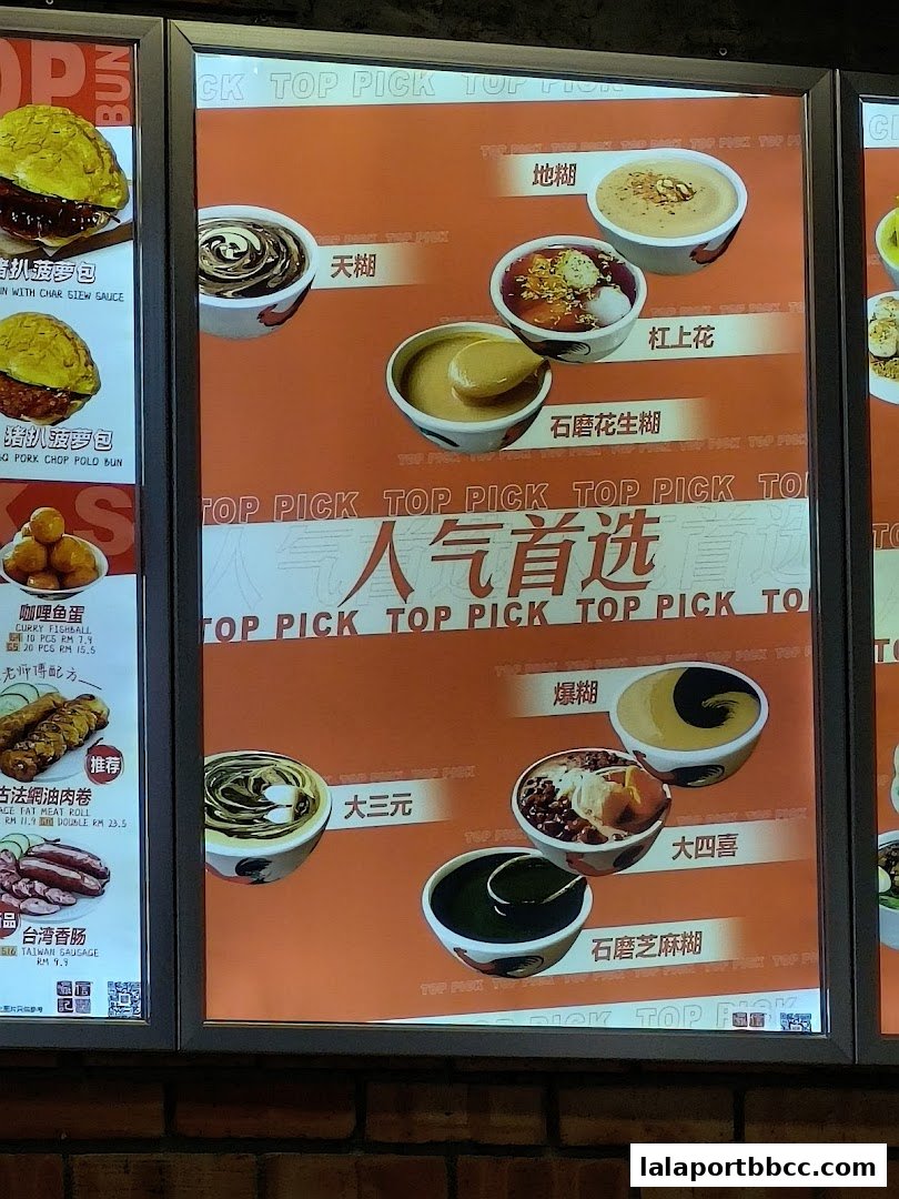 A brightly lit menu board showcasing various dessert bowls with Chinese and English names.