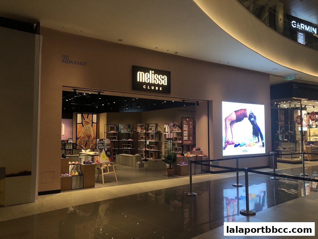 The Clube Melissa shoe store entrance with displays of shoes and a large illuminated advertisement.
