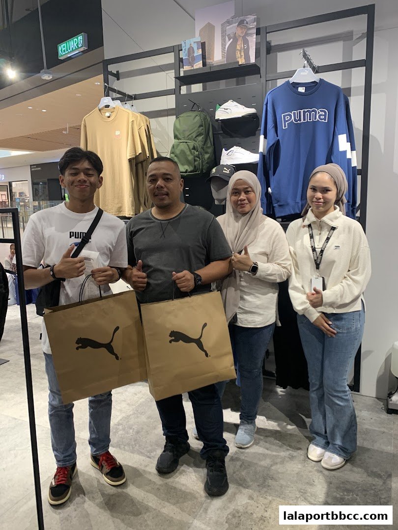 A group of people posing with shopping bags in a PUMA store.