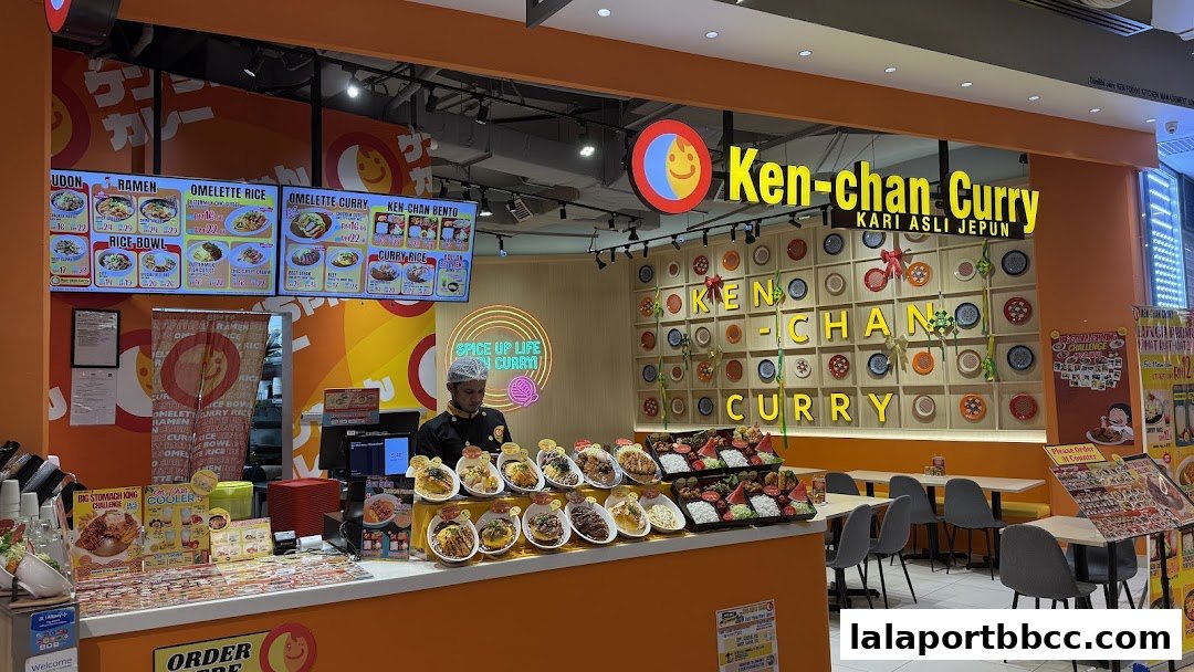 Ken-chan Curry shop front with a display of curry dishes and a digital menu.