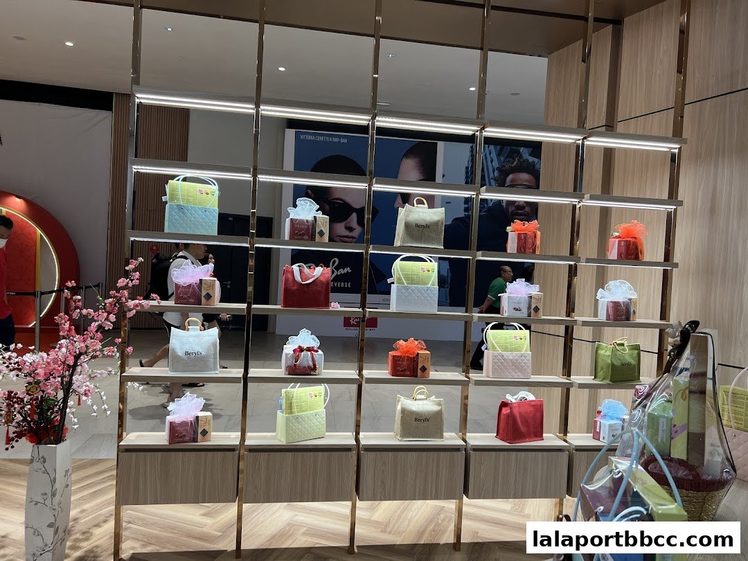 A display of Beryls Chocolate gift bags and boxes on shelves, with decorative flowers.
