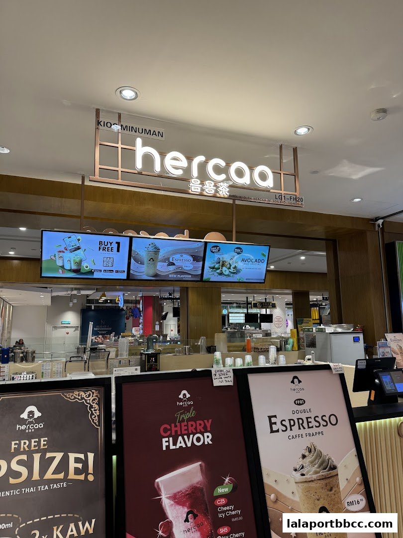 The front of a Hercaa beverage shop with illuminated signage and promotional displays.